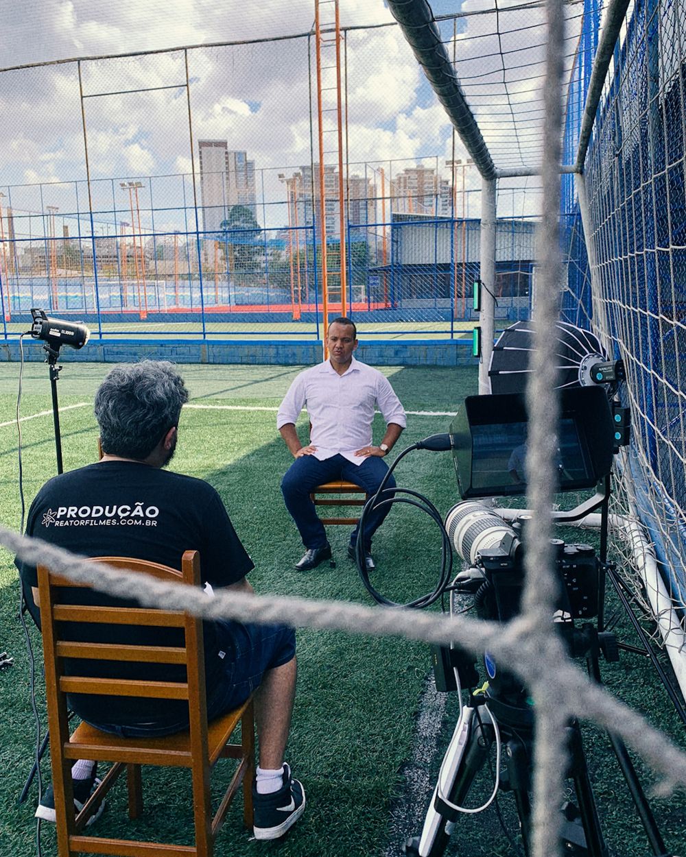Equipe da Reator entrevistando um cliente num campo de futebol