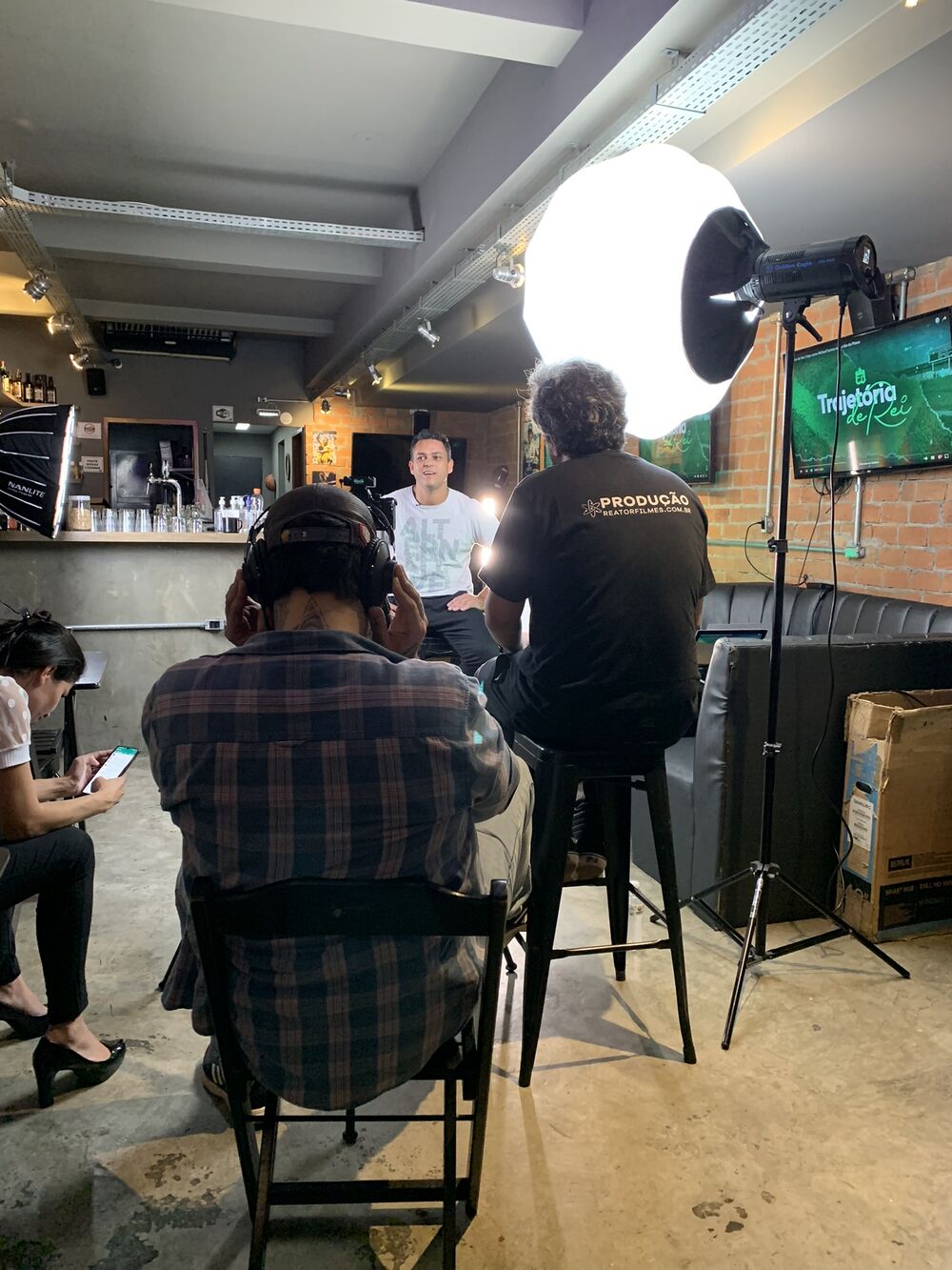 Bastidor de uma entrevista num bar, com a equipe da Reator e luz de estúdio